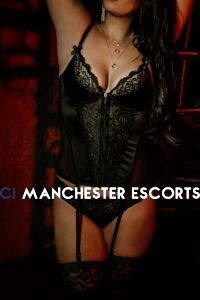 taylor stood in red room in black laced bodysuit